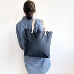 A woman wears the bag over the shoulder.