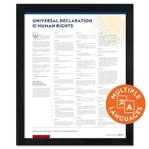 Könnte beinhalten: Ein gerahmter Druck der Allgemeinen Erklärung der Menschenrechte mit schwarzem Text auf weißem Hintergrund, einem Sonnenstrahl-Grafikmotiv in der oberen rechten Ecke und einem runden orangefarbenen Abzeichen mit der Aufschrift Multiple Languages.
