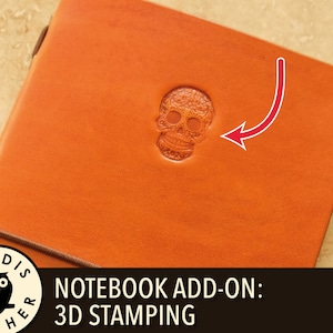 Può includere: Quaderno in pelle arancione con un design a teschio stampato in 3D. Il quaderno ha una chiusura elastica marrone e il testo "NOTEBOOK ADD-ON: 3D STAMPING". Il quaderno è di Leodis Leather.