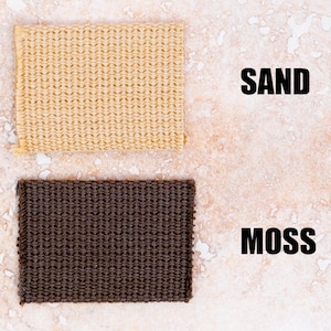 May include: Two fabric swatches, one beige and one dark brown, labelled "SAND" and "MOSS" respectively.