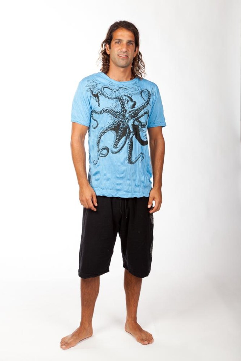 May include: A light blue short-sleeve t-shirt featuring a large black octopus graphic printed on the front, paired with black knee-length shorts that have an elastic waistband and a drawstring closure, creating a casual two-piece outfit.