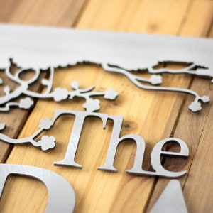 Close up of raw steel on the metal family name sign. Placed on a wood plank.