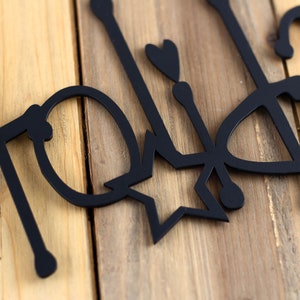 Close up of matte black powder coat on our Happy Holidays metal wall art.