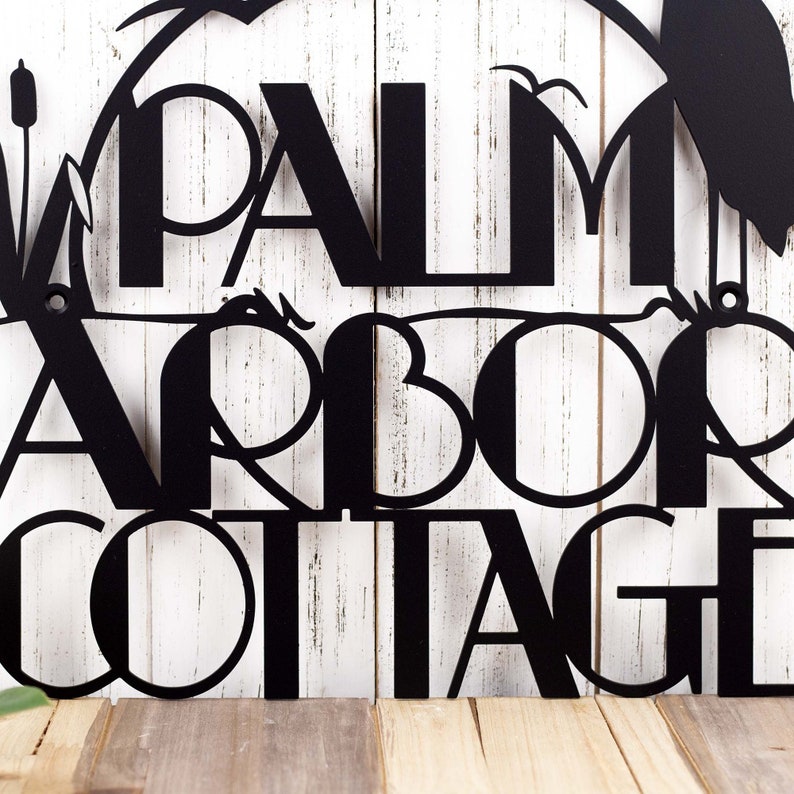 Art deco metal house name plaque with heron and cattails lake scene, in matte black powder coat.
