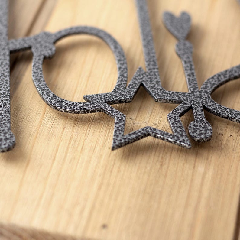 Close up of silver vein powder coat on our Happy Holidays metal wall art.