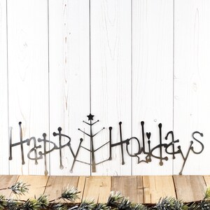 Happy Holidays metal wall art with Christmas tree, in raw steel.