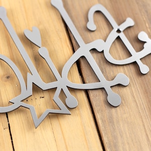 Close up of raw steel powder coat on our Happy Holidays metal wall art.