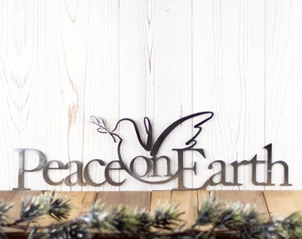 Puede incluir: Decoración de pared de metal con una paloma con una rama de olivo en su pico y las palabras "Peace on Earth".