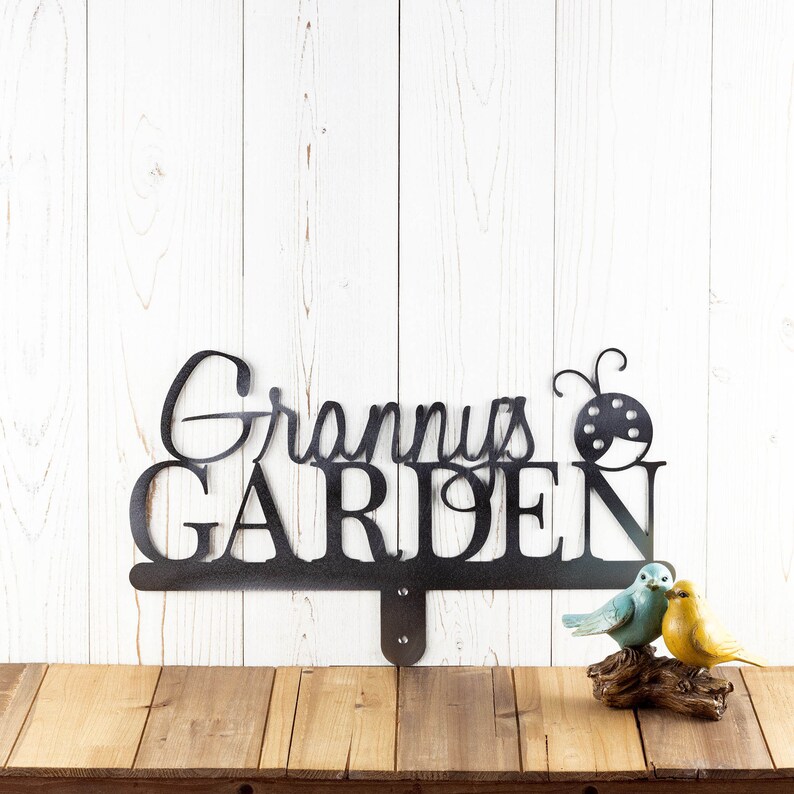 Garden name metal yard sign, with a ladybug silhouette, in raw steel.