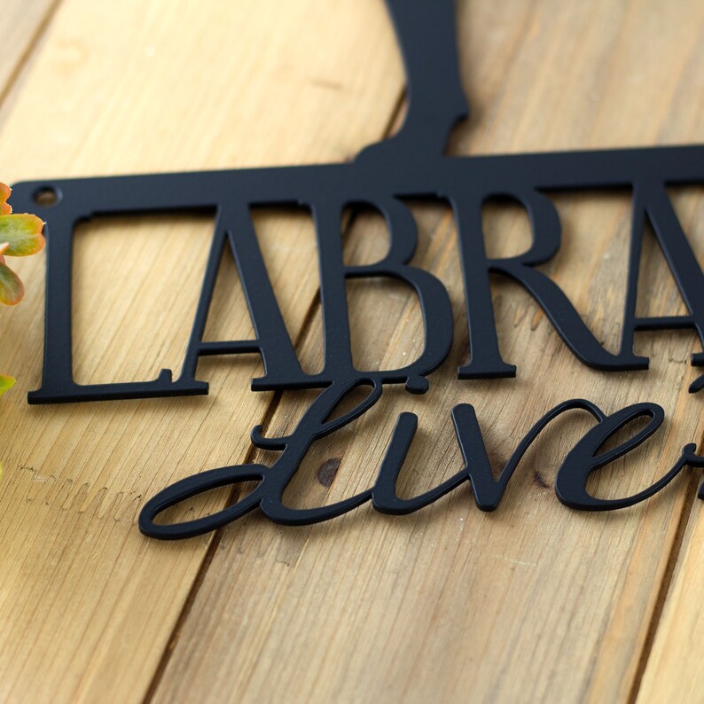 Close up of matte black powder coat on our Labradors Live Here metal wall art.