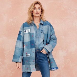 Puede incluir: Chaqueta vaquera patchwork en tonos azules, con pequeños detalles bordados en rojo y parches. La chaqueta se lleva sobre una camisa vaquera y unos vaqueros. El estilo es casual y moderno.