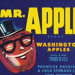 May include: A vintage illustration of a red apple wearing a top hat and glasses. The apple is smiling and has a dimpled cheek. The text "Mr. Apple Brand Washington Apples" is printed below the apple. The text "Contents one bushel Produce of U.S.A." is printed below the brand name. The text "Prentice Packing & Cold Storage Co. Yakima Washington" is printed at the bottom of the image.