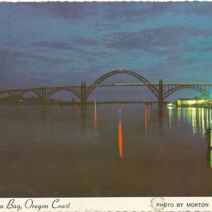 Oregon : carte postale vintage de la baie de Yaquina au crépuscule sur la côte de l'Oregon. Cette carte postale de la côte de l'Oregon date d'environ 1986.