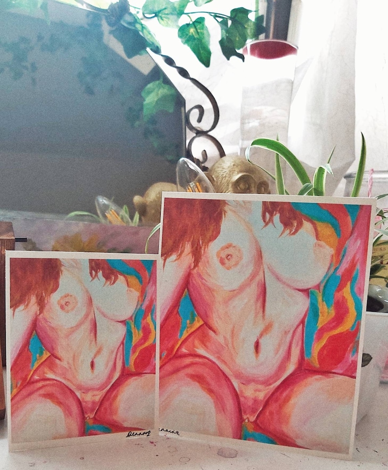 May include: Two prints of a nude female figure with long red hair. The figure is painted in a realistic style with a soft, warm color palette. The background is a vibrant mix of red, orange, yellow, and blue.