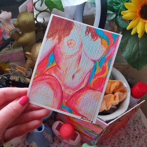 May include: A colorful drawing of a person's torso with a rainbow background. The drawing is on a white card with the word "burning" written in pink at the bottom.