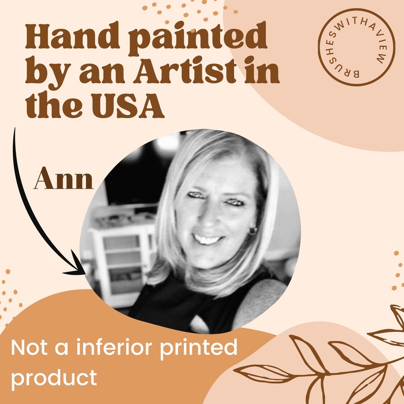 May include: A black and white photo of a woman, Ann, with the text "Hand painted by an Artist in the USA" and "Not a inferior printed product" on a peach background. The text "Brushes With A View" is in a circle with a brown background.