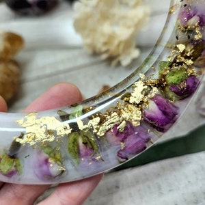 May include: A white crescent-shaped resin tray with dried flowers and gold leaf accents.