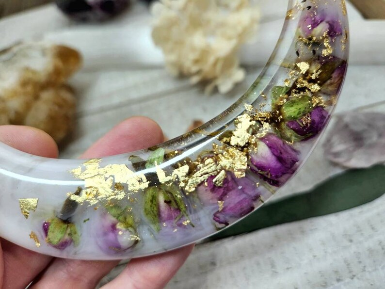 May include: A white crescent-shaped resin tray with dried flowers and gold leaf accents.