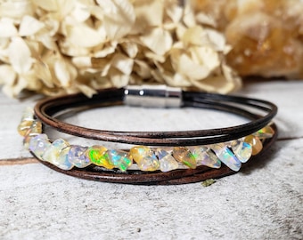 May include: A brown leather bracelet with a magnetic clasp and a row of iridescent opal chips.
