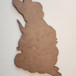 Peut inclure: Une d&eacute;coupe en bois brun d'un lapin debout, les oreilles dress&eacute;es.