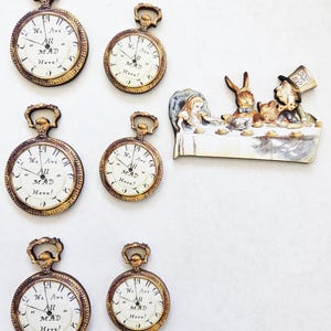 May include: An assortment of antique-style pocket watches and a Mad Hatter tea party illustration. The pocket watches have gold-toned frames and white faces with the text "We Are All MAD Here!". The tea party scene depicts Alice, the Mad Hatter, and the March Hare.