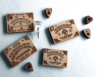 May include: Four miniature wooden Ouija boards with the words "YES" and "NO" at the top, and the letters of the alphabet, numbers 1-9 and 0, and the words "GOOD BYE" printed on them.  Each board has a small wooden planchette in the shape of a heart.