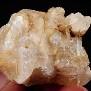 May include: A cluster of translucent, milky white quartz crystals with a rough, natural texture. The crystals are clustered together in a random, organic shape.