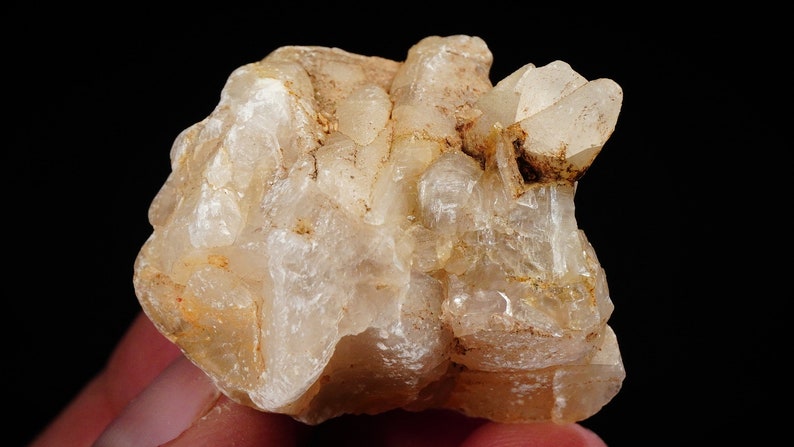 May include: A cluster of translucent, milky white quartz crystals with a rough, natural texture. The crystals are clustered together in a random, organic shape.