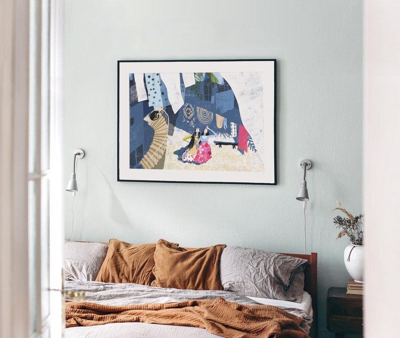 May include: A framed abstract art print with a blue, white, and yellow color scheme. The print features a stylized cityscape with figures in the foreground.
