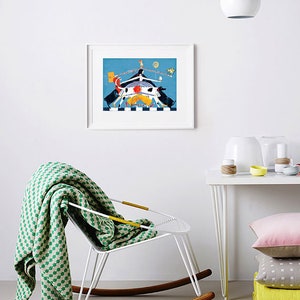 May include: A framed illustration of a colorful abstract scene with a white rocking chair and a green and white blanket draped over it. The illustration features a blue background with a white, orange, and yellow figure in the center. There is a white table with a white lamp and a stack of colorful pillows.