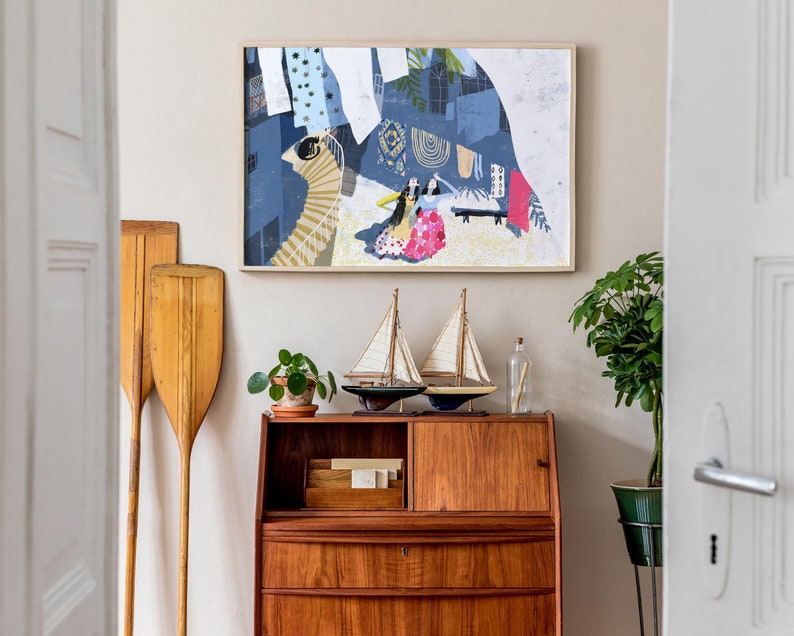 May include: A wooden vintage style secretary desk with three drawers and a top shelf. The desk is decorated with two small sailboats, a potted plant, and a glass bottle. A framed abstract painting with a blue, white, and pink color scheme hangs on the wall behind the desk.