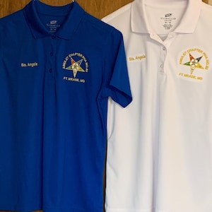 May include: Two white and blue polo shirts with the text "Sis. Angela" and a gold embroidered emblem with the text "Amulett Chapter PHA No. 85 FT. MEADE, MD"