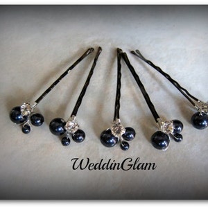 May include: Six black hair pins with a cluster of three black pearls and a rhinestone on each pin.