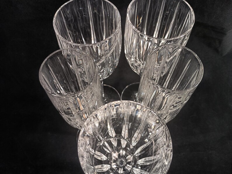 Vintage Mikasa Uptown clear heavy cut crytal stemware. This 5 piece set consists of three 9 inch water goblets and two 9 1/2 inch fluted champagne glasses. The bowls are vertically cut and polished from the rim to the stem and one horizontal spiral around the bowl. The tall slender stems are six-sided and curver gracerully into thesix-segmented foot.