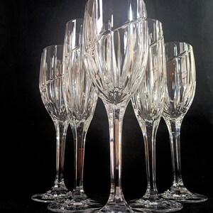 Vintage Mikasa Uptown clear heavy cut crytal stemware. This 5 piece set consists of three 9 inch water goblets and two 9 1/2 inch fluted champagne glasses. The bowls are vertically cut and polished from the rim to the stem and one horizontal spiral around the bowl. The tall slender stems are six-sided and curver gracerully into thesix-segmented foot.