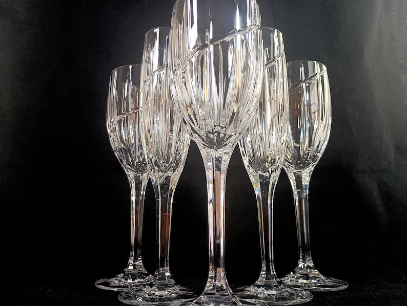 Vintage Mikasa Uptown clear heavy cut crytal stemware. This 5 piece set consists of three 9 inch water goblets and two 9 1/2 inch fluted champagne glasses. The bowls are vertically cut and polished from the rim to the stem and one horizontal spiral around the bowl. The tall slender stems are six-sided and curver gracerully into thesix-segmented foot.