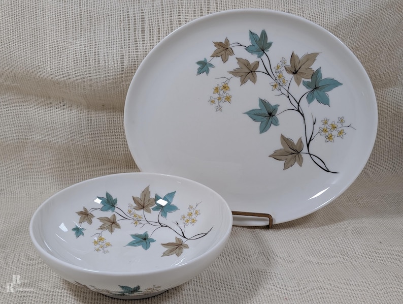 Mid‑century Syracuse China Woodbine pieces including an oval platter and serving bowl with the aqua and brown floral motif on a bright white glaze.