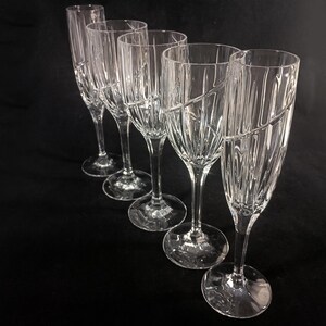 Vintage Mikasa Uptown clear heavy cut crytal stemware. This 5 piece set consists of three 9 inch water goblets and two 9 1/2 inch fluted champagne glasses. The bowls are vertically cut and polished from the rim to the stem and one horizontal spiral around the bowl. The tall slender stems are six-sided and curver gracerully into thesix-segmented foot.
