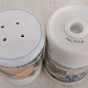 Mikasa Garden Harvest CAC29 stoneware Salt and Pepper shakers with fruit and leaf border on cream glaze.