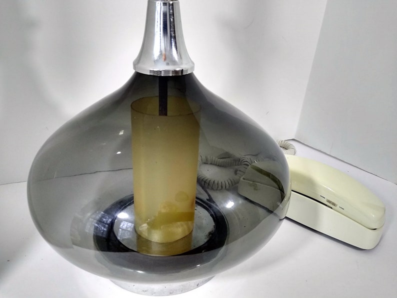 Mid Century Modern Minimalist Blenko Art Glass Table Lamp. Hand blown smoke glass garlic shape body, chrome finish neck and base. Fiberglass light diffuser inside glass body for mood light.