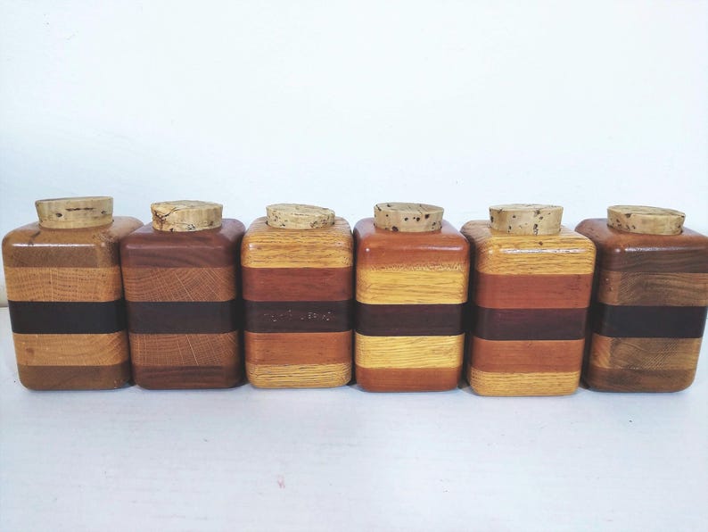 Mid Century Turned Stacked Layered Wood Spice Containers with Cork Stoppers. Set of 6 wooden spice jars  ade of Layers of various varieties of dark and light colored wood stacked together, turned, and finished to warm rich layers of natural wood.