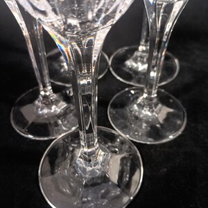 Vintage Mikasa Uptown clear heavy cut crytal stemware. This 5 piece set consists of three 9 inch water goblets and two 9 1/2 inch fluted champagne glasses. The bowls are vertically cut and polished from the rim to the stem and one horizontal spiral around the bowl. The tall slender stems are six-sided and curver gracerully into thesix-segmented foot.