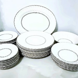 Mid Century Homer Laughlin Arcadia Dinnerware. Silver Platinum wreath of leaves around inner circle, Platinum trim on scalloped rimmed white china. Plates, bowls and serving pieces.