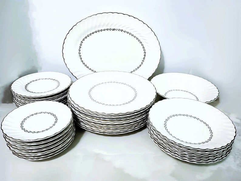 Mid Century Homer Laughlin Arcadia Dinnerware. Silver Platinum wreath of leaves around inner circle, Platinum trim on scalloped rimmed white china. Plates, bowls and serving pieces.