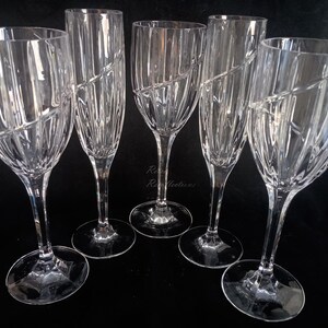 Vintage Mikasa Uptown clear heavy cut crytal stemware. This 5 piece set consists of three 9 inch water goblets and two 9 1/2 inch fluted champagne glasses. The bowls are vertically cut and polished from the rim to the stem and one horizontal spiral around the bowl. The tall slender stems are six-sided and curver gracerully into thesix-segmented foot.