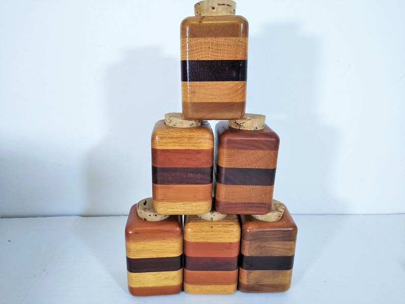 Mid Century Turned Stacked Layered Wood Spice Containers with Cork Stoppers. Set of 6 wooden spice jars  ade of Layers of various varieties of dark and light colored wood stacked together, turned, and finished to warm rich layers of natural wood.