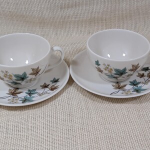 Mid‑century Syracuse China Woodbine 2 cup and saucers sets with the aqua and brown floral motif on a bright white glaze.