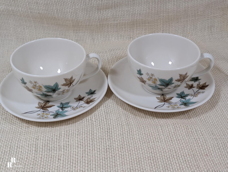 Mid‑century Syracuse China Woodbine 2 cup and saucers sets with the aqua and brown floral motif on a bright white glaze.