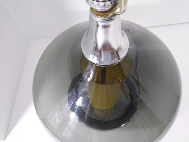 Mid Century Modern Minimalist Blenko Art Glass Table Lamp. Hand blown smoke glass garlic shape body, chrome finish neck and base. Fiberglass light diffuser inside glass body for mood light.