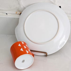 Jonas Roberts Japan snack set with white yin yang snack plate with orange diamonds and orange cup with white diamond pattern